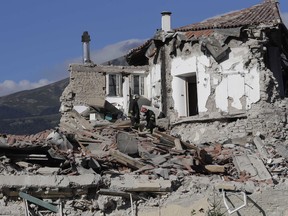 Rescuers search through debris following an earthquake in Amatrice, Italy, Wednesday, Aug. 24, 2016. The magnitude 6 quake struck at 3:36 a.m. (0136 GMT) and was felt across a broad swath of central Italy, including Rome where residents of the capital felt a long swaying followed by aftershocks.