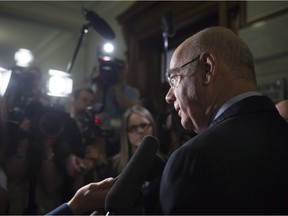 Quebec Transport Minister Jacques Daoust responding to reporters' questions on Wednesday, May 18, 2016 at the legislature in Quebec City.