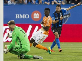 Montreal Impact's Matteo Mancosu, right, takes a shot at Houston Dynamo's goalkeeper Joe Willis as Dynamo's Jalil Anibaba (2) defends during first half MLS soccer action in Montreal, Saturday, August 6, 2016.