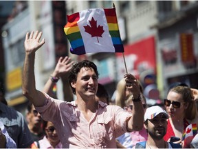 Prime Minister Justin Trudeau waves a flag as he takes part in the annual Pride Parade in Toronto July 3, 2016.