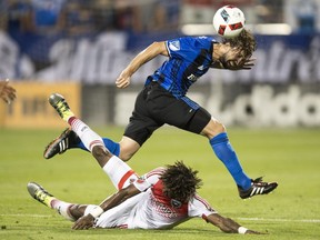 Montreal Impact midfielder Marco Donadel, top, battles with D.C. United forward Kennedy Igboananike during first half MLS action Wednesday, August 24, 2016 in Montreal.