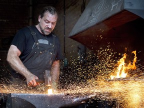 Master Blacksmith Mathieu Collette forges a piece of iron at his workshop in Montreal, Wednesday, August 10, 2016.