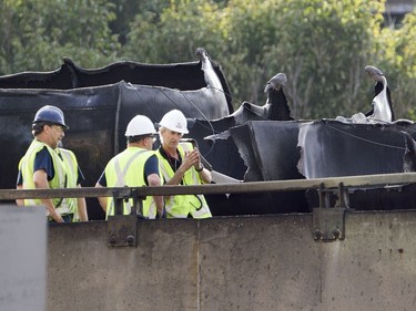 Workers inspect the scene of Tuesday's fatal truck crash and fire on highway 40 west at Lajeunesse in Montreal, Wednesday August 10, 2016. The 40 westbound remains closed.
