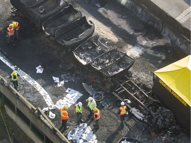 Workers inspect the scene of Tuesday's fatal truck crash and fire on highway 40 west at Lajeunesse in Montreal, Wednesday August 10, 2016. The 40 westbound remains closed.