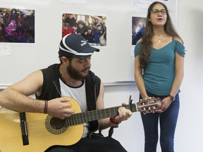 Syrian refugees Najm Eddin Zabad, left, and Carla Egho perform Céline Dion's song "Parler à mon père" for Quebec immigration minister, Kathleen Weil at Centre social d'aide aux immigrants in Ville Emard, Montreal, Thursday August 11, 2016.  The minister was visiting Syrian and African government-sponsored refugees at the CSAI.
