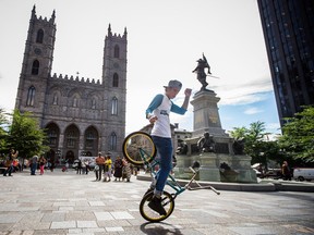 Canadian flatlander Jean William Prevost, who is also the organizer for the Real City Spin 2015 BMX flatland competition, performs a trick on his BMX bike at Place d'Armes in Montreal on Wednesday, August 26, 2015. (Dario Ayala / Montreal Gazette)