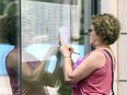 Denise Granger compares her hand-written notes to the Festival des films du monde movie calendar in the window of the Imperial Cinema in Montreal Friday August 26, 2016.