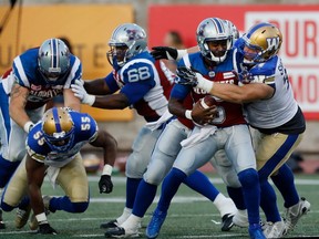 Montreal Alouettes quarterback Kevin Glenn is sacked by Winnipeg Blue Bombers defensive lineman Keith Shologan during CFL action at Molson Stadium in Montreal on Friday August 26, 2016. Montreal Alouettes guard Philip Blake, centre, blocks Winnipeg Blue Bombers defensive lineman Jamaal Westerman.