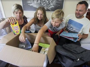 Denise Warnke-Nowik and Daniel Nowik go through a box of school supplies with Bronwyn and Sebastian, two of their three children at their home in Hudson. (John Mahoney / MONTREAL GAZETTE)
