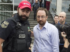 Jonathan Bettez is escorted out of the Palais de Justice of Trois-Rivières Aug. 30, 2016.