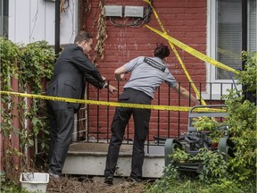 Verdun Mayor Jean-Jean-François Parenteau, left, and Animex animal technician Ariane Duplessis, right, look at the location where an escaped python hid under a home located on Willibrord street in Verdun in Montreal on Wednesday, August 31, 2016.
