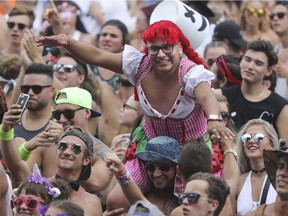 A man enjoys the music while perched on the shoulders of another man at the ÎleSoniq electronic-music festival at Parc Jean-Drapeau in Montreal Friday, August 5, 2016.