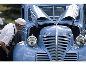 Vintage cars roll into Baie-d'Urfé Aug. 7. Adolphe Vanmolle, pictured, checks out a classic car at the 2011 event. (Dario Ayala/MONTREAL GAZETTE)
