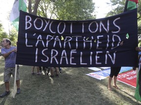 Protests hold an anti-Israel sign in the march of the World Social Forum in Montreal Tuesday, August 9, 2016.