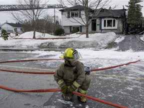 Firefighters clean up after battling a fire in Île-Perrot. (Peter McCabe / THE GAZETTE)