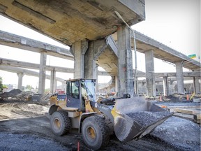 A bulldozer carries a load of gravel under overpasses at the east end of the Turcot Interchange reconstruction project.