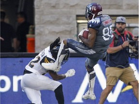 Montreal Alouettes' B.J. Cunningham comes down with the pass on top of Hamilton Tiger-Cats' Courtney Stephen during Canadian Football League game in Montreal Friday July 15, 2016.