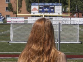 A woman who alleges she was sexually assaulted on John Abbott College campus while taking a summer class in June stands in front of the school's football field on Saturday July 30, 2016.