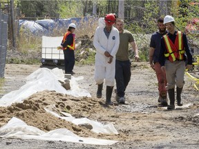 MONTREAL, QUE.: MAY 15, 2014 --  Workrs walk past a mound of dirt at Reliance Power Equipment Ltd. in Pointe Claire west of Montreal, Thursday, May 15, 2014, during soil decontamination operations.  (Phil Carpenter / THE GAZETTE)  ORG XMIT: 49974