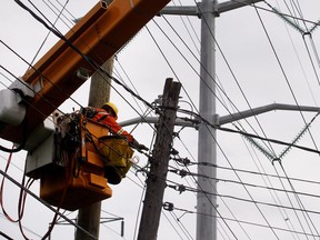 A Hydro-Québec linesman replaces a broken pole and transfers the power lines to a new pole in Montreal in 2015.