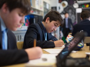 Anastasios Patsilivas (at left) and David Lucadomo, students at Loyola High School, work on an art project in which they have photographed an image with their iPads and overlaid a grid, using a drawing app, so they can replicate the image on paper.  (Photo courtesy of Loyola High School)