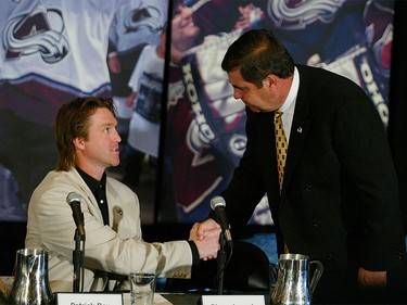 May 28, 2003:  Colorado Avalanche General Manager Pierre Lacroix (R) shakes goalie Patrick Roy's hand as he announces his retirement from the NHL after 18 seasons, at the Pepsi Center in Denver, Colorado. Roy was the NHL's career leader with 551 victories and 1,029 games played, a three-time winner of the Conn Smythe Trophy and a four-time Stanley Cup champion.