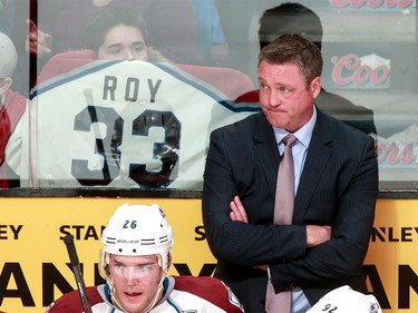 March 18, 2014: Colorado Avalanche head coach Patrick Roy looks on as a fan holds an old Patrick Roy Canadiens jersey during the third period of their NHL hockey match against the Montreal Canadiens at the Bell Centre in Montreal.