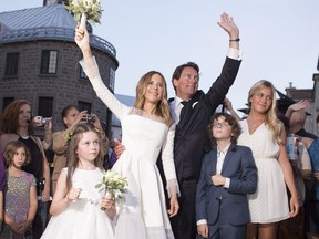 Parti Quebecois Leader Pierre-Karl Peladeau and Julie Snyder waves to the crowd after getting married, Saturday, August 15, 2015 in Quebec City. the couple are flanked by their children Romy, Thomas and Marie.