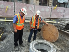 Robert Fortin, left, and Michel Guimont from Les Entreprises Michaudville inspect a new valve chamber. The water on St-Denis St. is ready to be turned on.