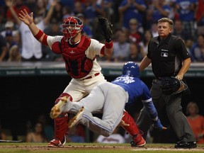 Ryan Goins of the Toronto Blue Jays scores ahead of the throw to Chris Gimenez during the second inning at Progressive Field on August 20, 2016, in Cleveland.