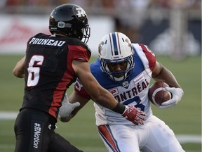Montreal Alouettes' Vernon Adams Jr. (3) fends off Ottawa Redblacks' Antoine Pruneau (6) for a touchdown during first half CFL action on Friday, Aug. 19, 2016 in Ottawa.