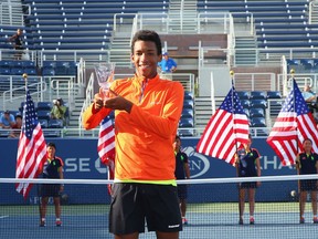 Montreal's Félix Auger-Aliassime with the trophy after defeating Miomir Kecmanovic of Serbia in the Junior Boys' Final on Day Fourteen of the 2016 U.S. Open at the USTA Billie Jean King National Tennis Center on September 11, in the Queens borough of New York City.