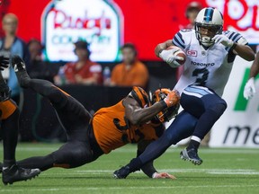 Toronto Argonauts' Brandon Whitaker, right, is brought down by B.C. Lions' Alex Bazzie as he carries the ball during the second half of a CFL football game in Vancouver, B.C., on Thursday July 7, 2016.