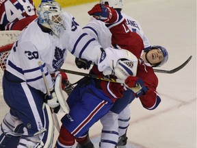 Toronto Maple Leafs' goalie Antoine Bibeau, left, pushes down Montreal Canadiens' William Bitten, right, in his crease during NHL rookie tournament action in London, Ont., on Saturday, Sept. 17, 2016.