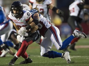 Ottawa Redblacks wide receiver Brad Sinopoli is tackled by Montreal Alouettes linebacker Bear Woods (48) during first half CFL football action, in Montreal on Thursday, September 1, 2016.
