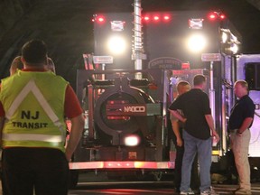 Bomb squad personnel stand around the scene of an explosion near the train station early Monday, Sept 19, 2016, in Elizabeth, N.J. A suspicious device found Sunday night in a trash can near a New Jersey train station exploded early Monday as a bomb squad robot attempted to disarm it. (Jessica Remo/NJ Advance Media via AP) ORG XMIT: NJNEW203