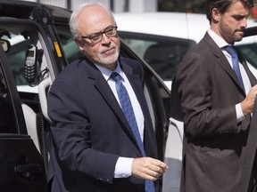 Quebec Finance Minister Carlos Leitao, left, arrives for a cabinet meeting at the legislature in Quebec City on Wednesday, August 17, 2016.