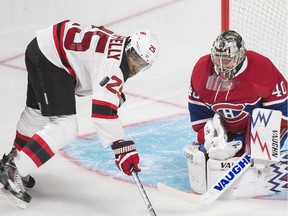 Montreal Canadiens goalie Charlie Lindgren makes a save as New Jersey Devils' Devante Smith-Pelly looks for the rebound during third period NHL pre-season hockey action in Montreal, Monday, September 26, 2016.