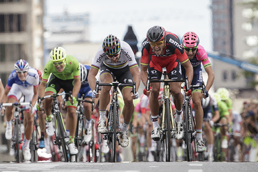 Cyclist Greg Van Avermaet of Belgium, in red, approaches the finish line in first place followed by Peter Sagan of Slovakia in second, in white, and Diego Ulissi of Italy in third, in pink, at the end of the Montreal edition of the Grand Prix Cycliste in Montreal on Sunday, September 11, 2016.