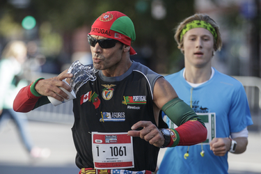 Runner Manuel Cobral attempts to take a drink of water as he takes part in the Rock 'N' Roll Montreal Marathon on Sunday, September 25, 2016.