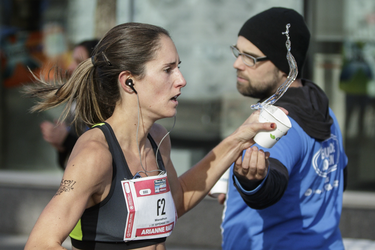 Runner Arianne Raby of Quebec grabs a cup of water as she takes part in the Rock 'N' Roll Montreal in Montreal on Sunday, September 25, 2016. Raby was the winner of the marathon in the women's category.