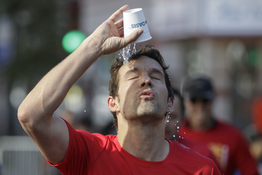 Runner Antoine Gervais splashes water over his head as he takes part in the Rock 'N' Roll Montreal Marathon on Sunday, September 25, 2016.