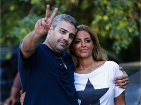 A file picture taken on Sept. 23, 2015 shows Canadian Al-Jazeera journalist Mohamed Fahmy (L) flashing the sign for victory as he celebrates with his wife Marwa after being dropped off by authorities in the upmarket Cairo suburb of Maadi following his release from prison with his colleague Baher Mohamed.