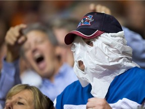 A Montreal Alouettes fan hides his face with a plastic bag while watching the team play the B.C. Lions in Vancouver on Friday Sept. 9, 2016.