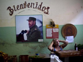 A photograph of Fidel Castro hangs under the Spanish word "Welcome" on the wall at a state-run food market in Havana, Cuba in 2014.