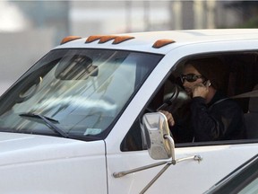 A driver talks on his mobile phone while driving. (File photo)