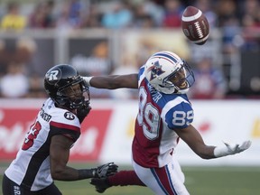 The ball drops out of reach of Montreal Alouettes wide receiver Duron Carter, right, as Ottawa Redblacks defensive back Forrest Hightower covers during second quarter CFL football action in Montreal on Thursday, June 30, 2016.