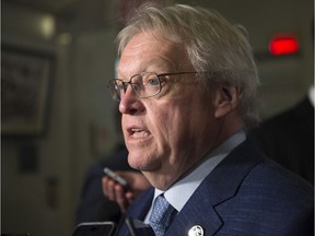 Quebec Health Minister Gaetan Barrette responds to reporters questions before entering a caucus meeting, Tuesday, April 19, 2016 at the legislature in Quebec City.