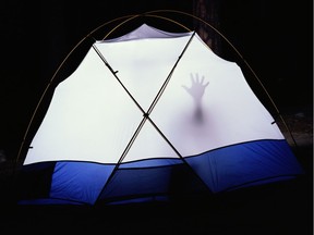 Hand  pressed against interior wall of  glowing tent, night