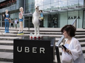 A woman walks past an Uber station outside a shopping mall in Beijing.